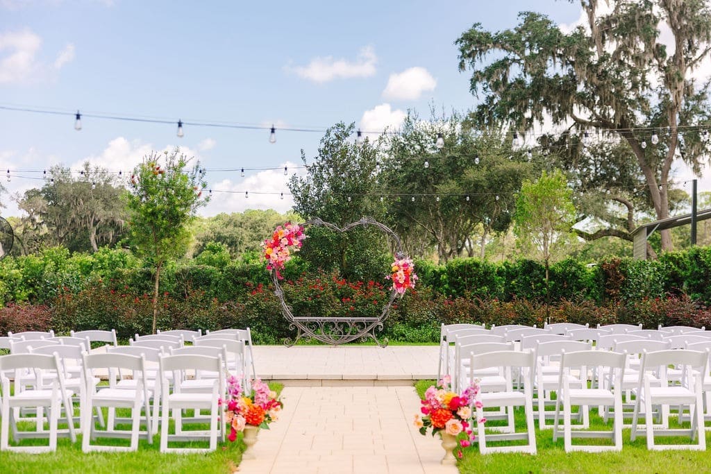 A closer look at the arch swags designed for this whimsical garden ceremony, bursting with vibrant poppies, dahlias, and roses.