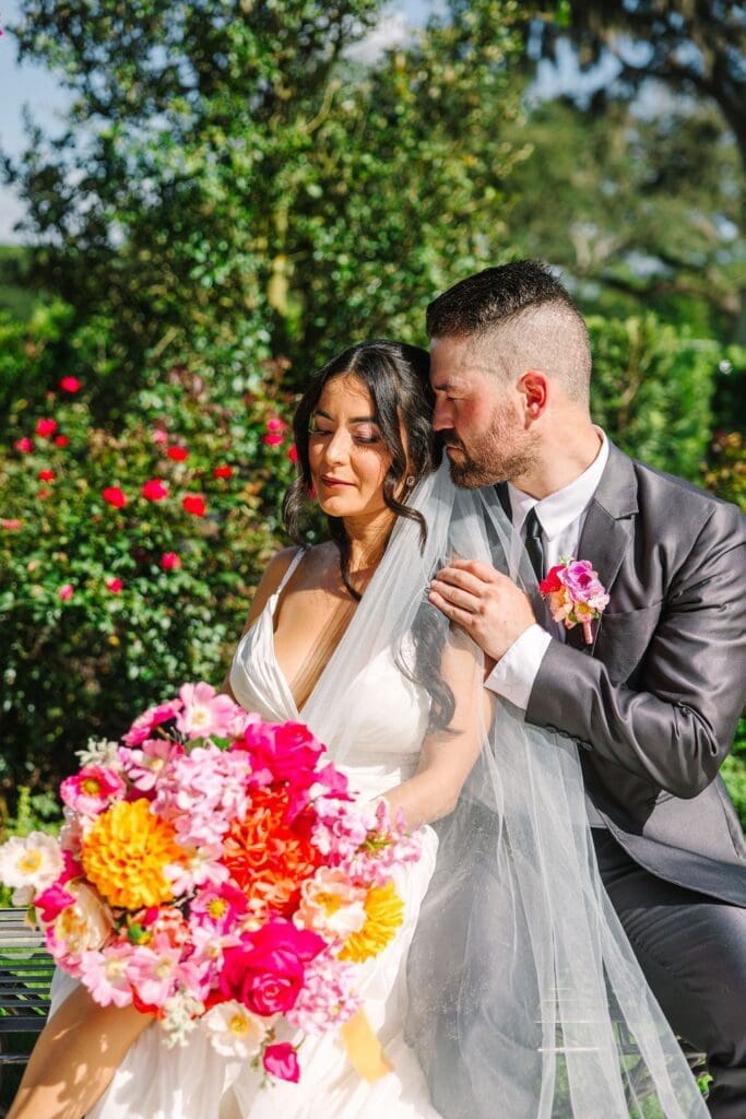 Bride and groom on their sweet moments highlighting the colorful florals