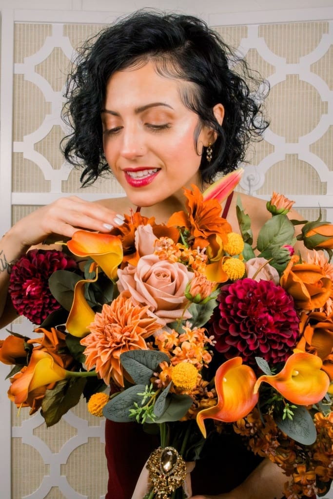 Colorful floral bouquet held and touched by a woman