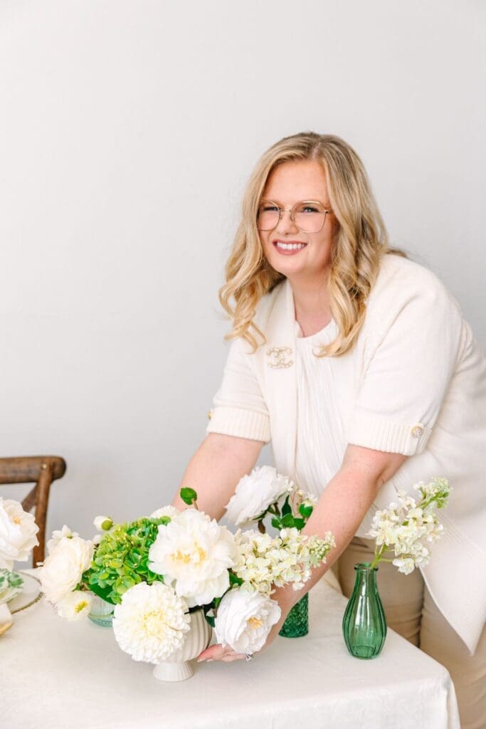 florist placing real touch flower wedding centerpiece on reception table